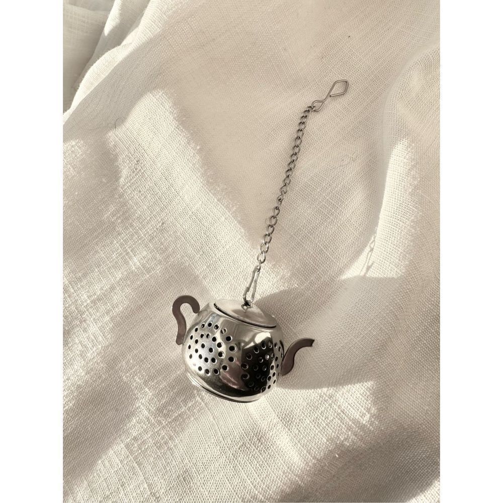 Silver colored teapot, tea diffuser